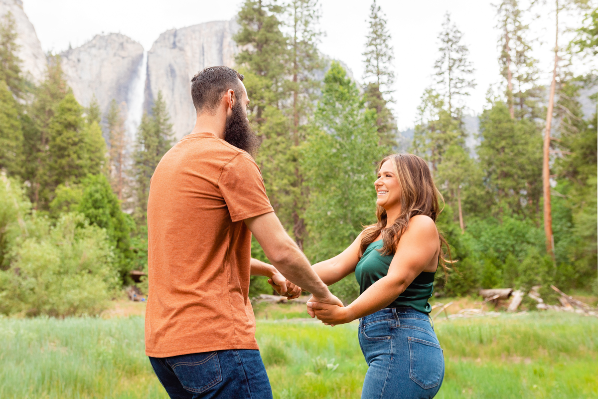 Engaged couple twirl at Yosemite National Park.