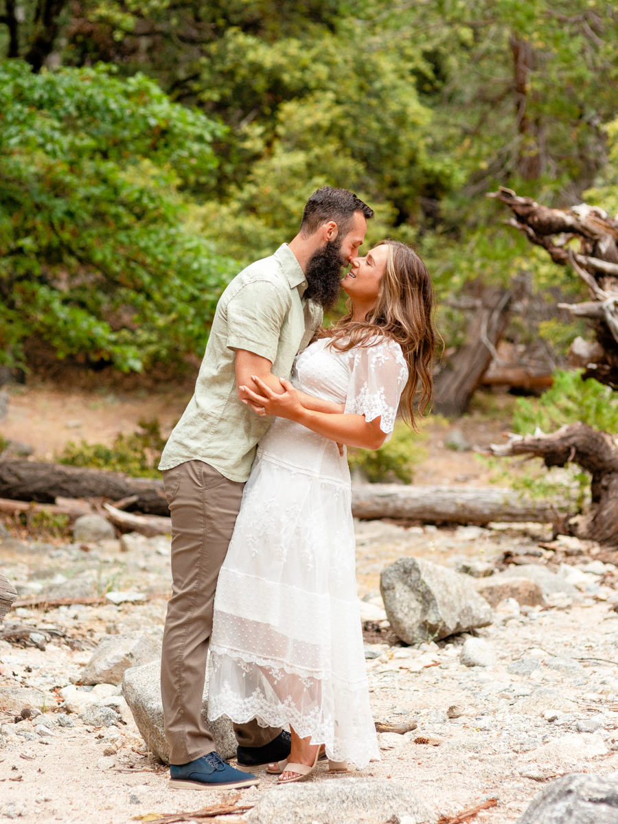 Man dips and kisses his fiancé during their Yosemite engagement session.